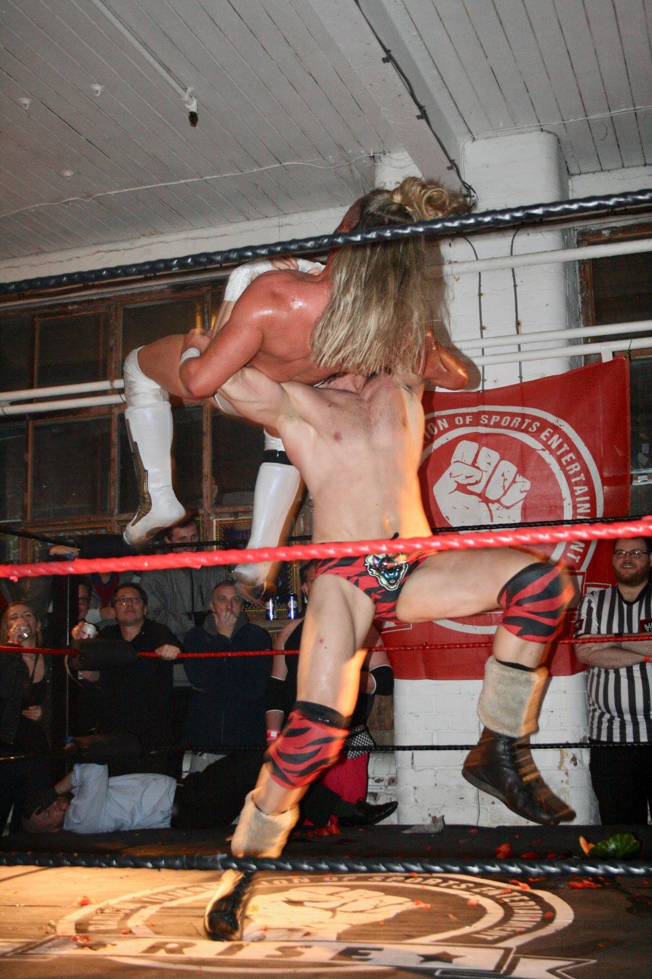 Action shot at rise underground pro wrestling showing a competitor throwing another competitor through the air