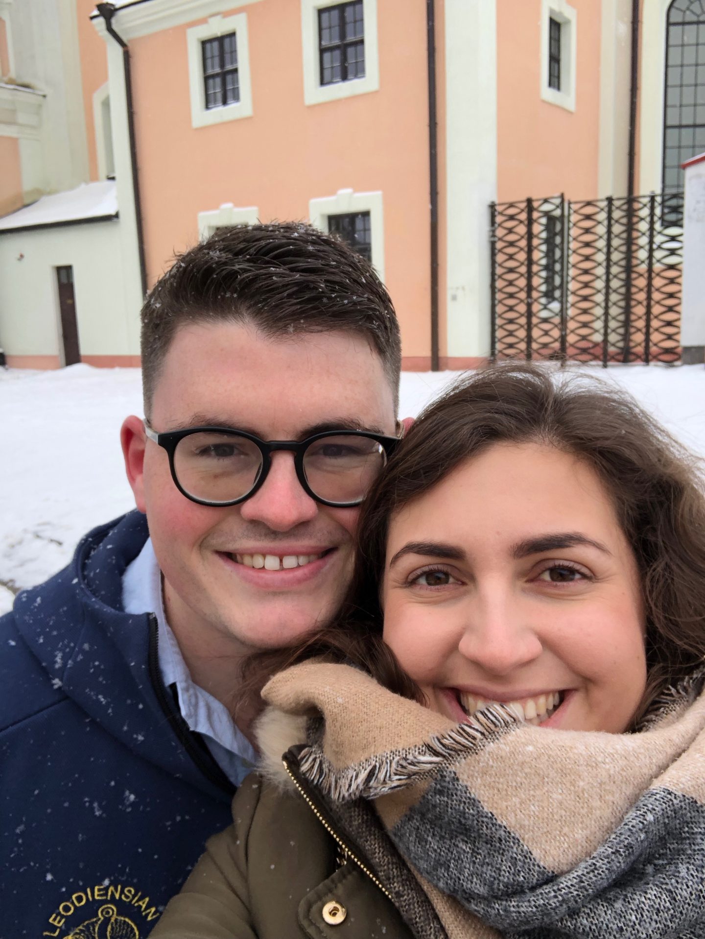 things to do in Vilnius in winter: a selfie of Nell and her boyfriend in the snow, smiling at the camera with rosy cheeks
