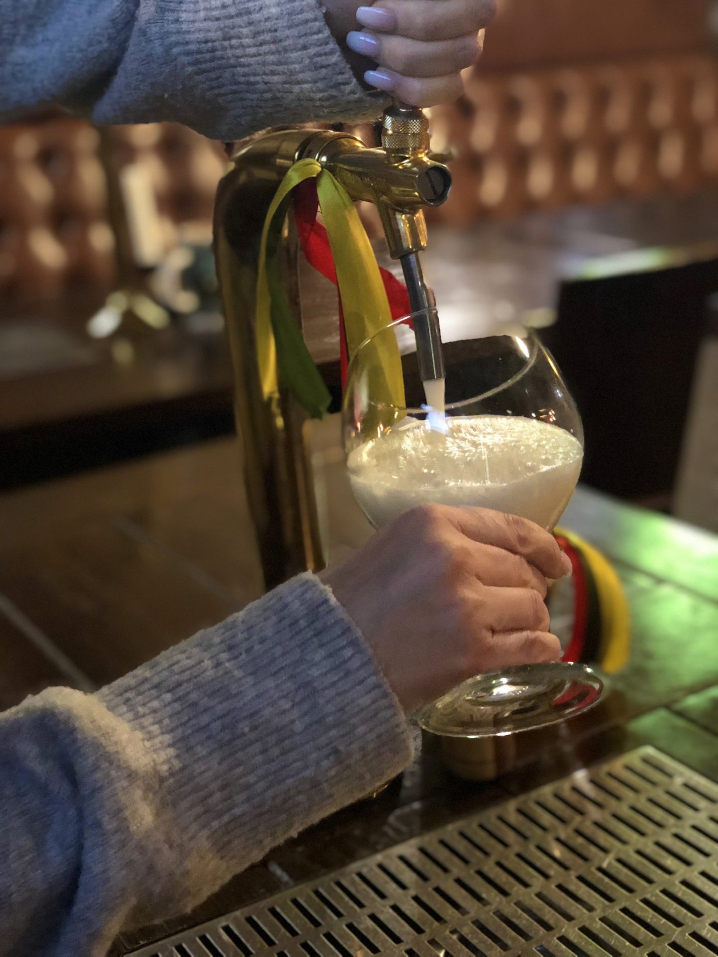 vilnius bars: two hands pulling a beer at a pour-your-own-beer bar