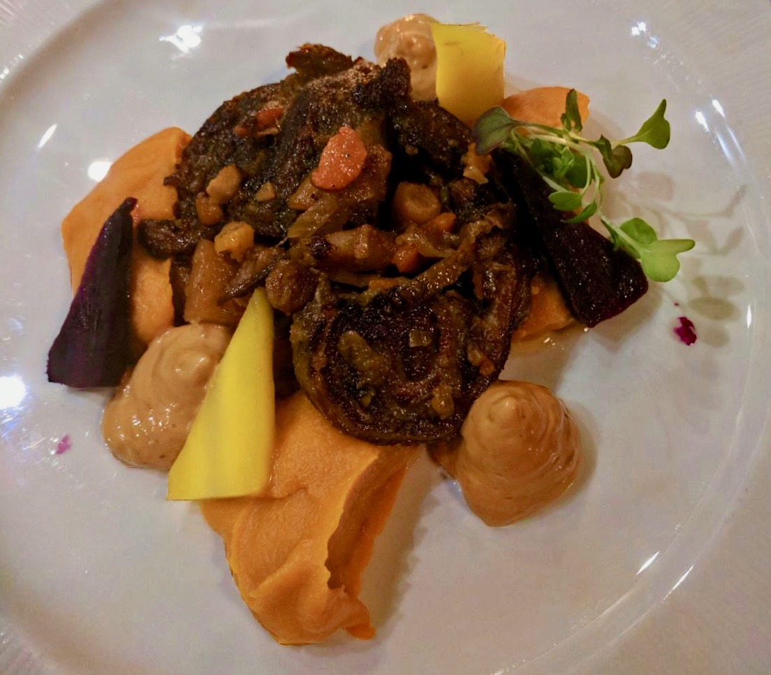 Goat with sweet potato, carrot and puree on a white plate