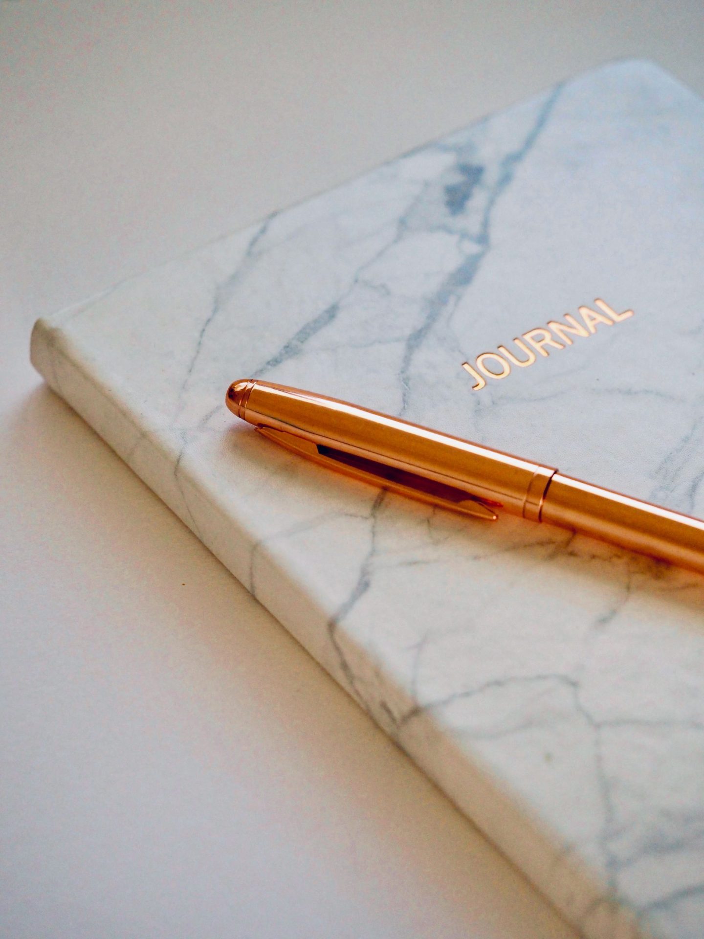 Staying positive during Coronavirus: a notebook with a marble design and the 'journal' written on the front