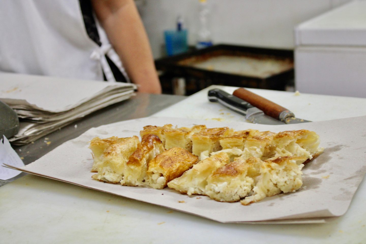traditional bulgarian food in sofia: banitsa on white paper inside a bakery